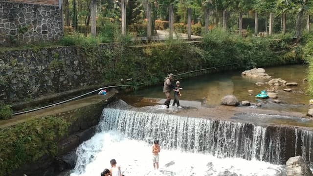 ola bersama ayah berjalan di bendungan untuk menebar ikan
